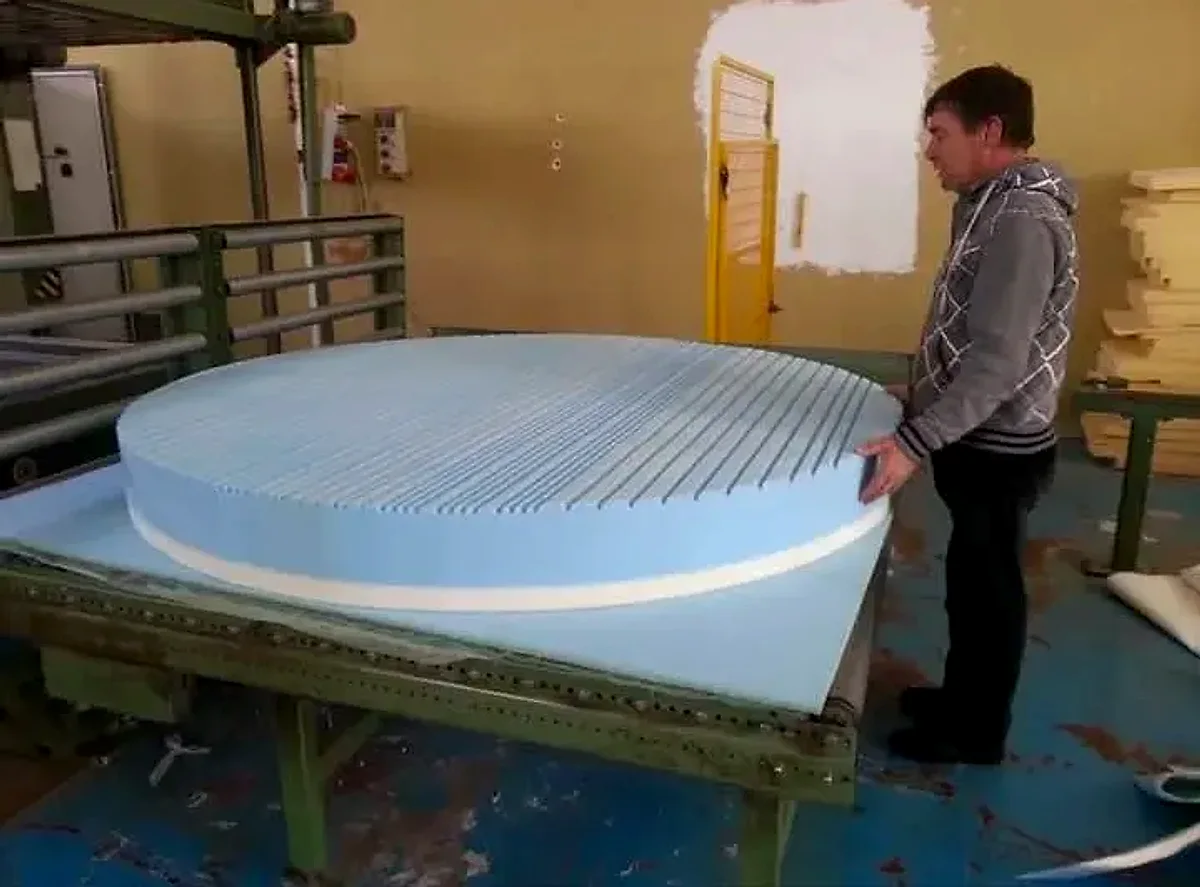 Materasso rotondo in memory foam azzurro con superficie scanalata controllato sul banco di lavoro